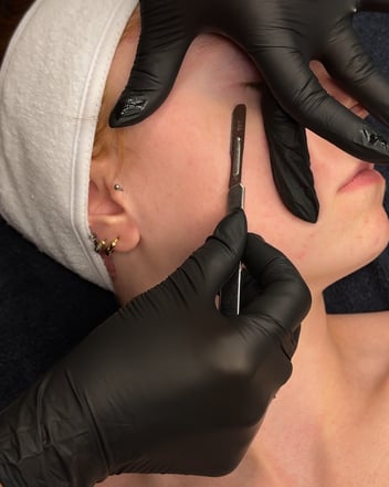 Client receiving the dermaplane portion of the Glass Skin Facial